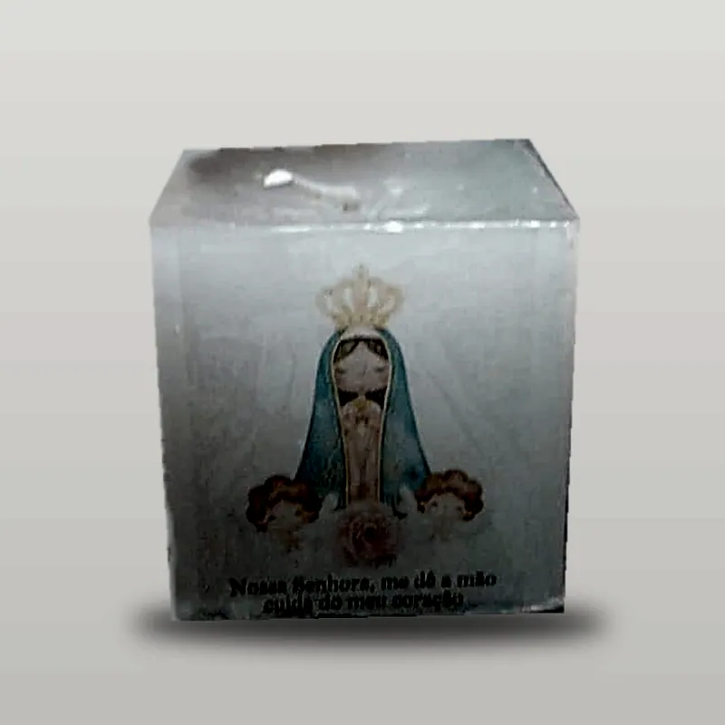 Vela em cubo com imagem de Nossa Senhora, sozinha sobre fundo claro