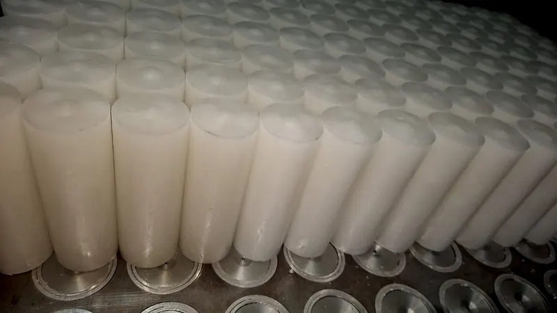 Fileiras de velas brancas sobre as formas, na fábrica